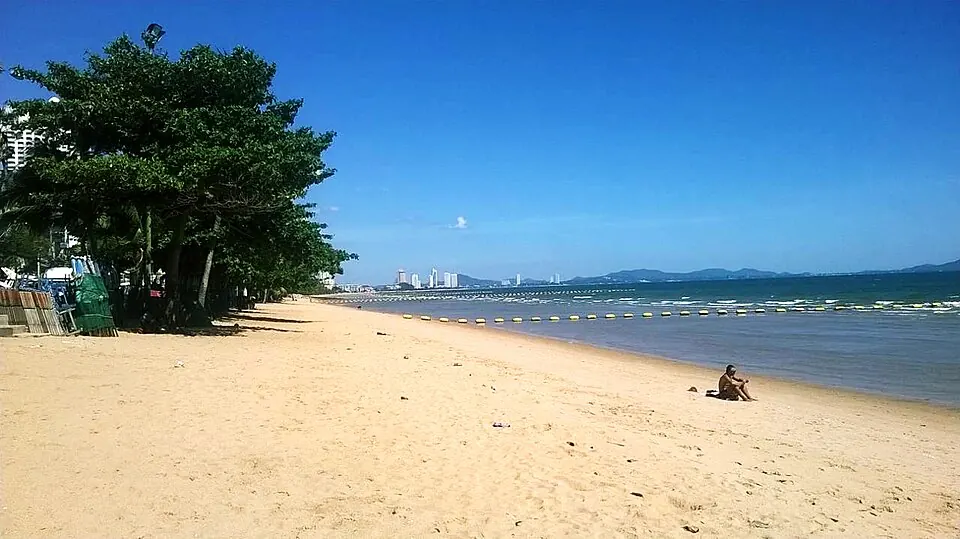 Sandy Jomtien Beach with trees along the shore south of Pattaya