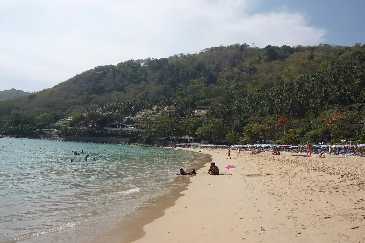 Nai Harn Beach and its sheltered-looking bay beneath the green headland
