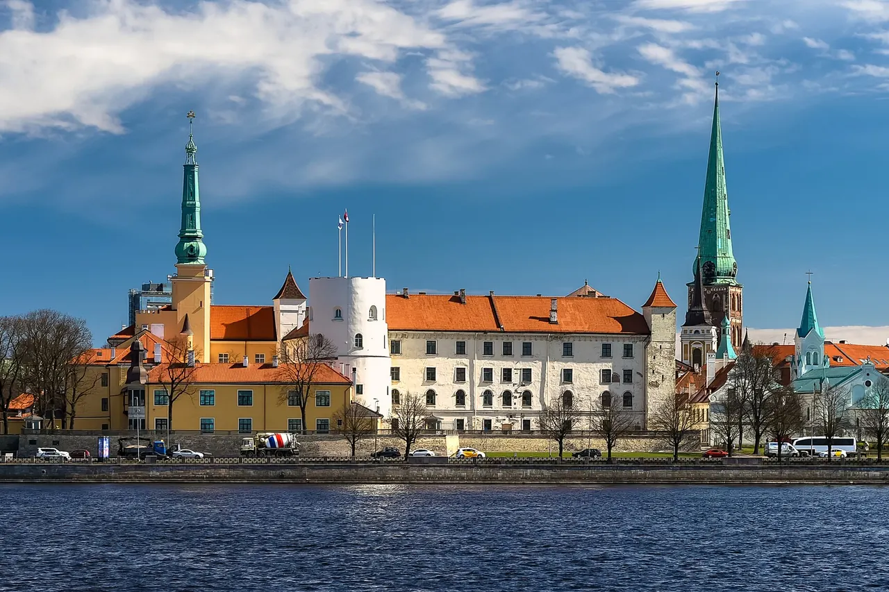 Pale walls and towers of Riga Castle beside the Daugava waterfront