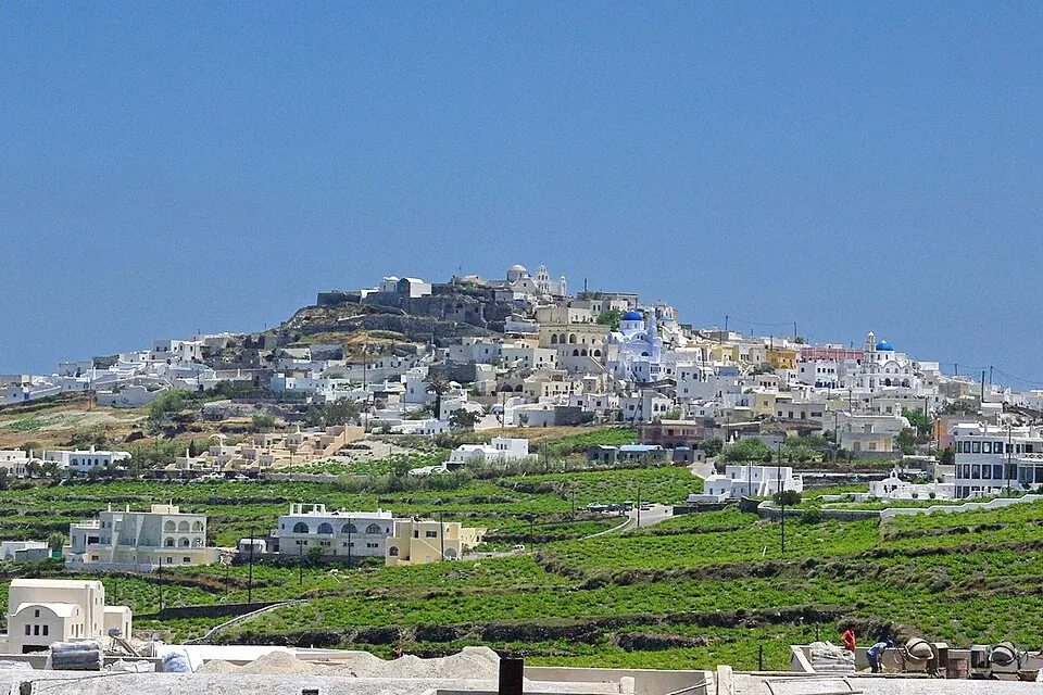 White buildings and the fortified upper village of Pyrgos rising above Santorini's inland slopes