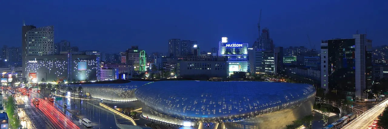 The illuminated curved exterior of Dongdaemun Design Plaza at night