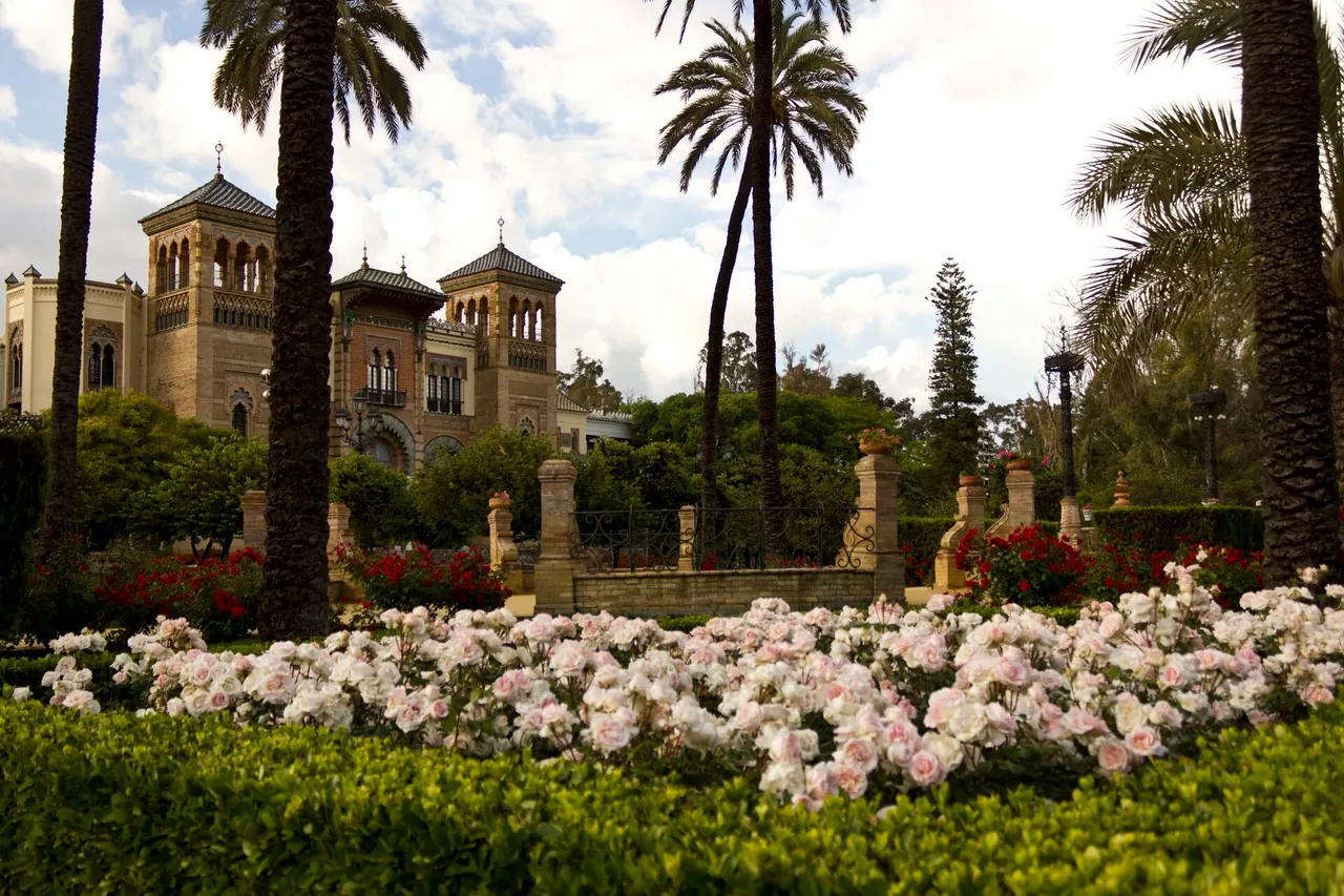 Palm trees and flowering garden beds in Maria Luisa Park, Seville