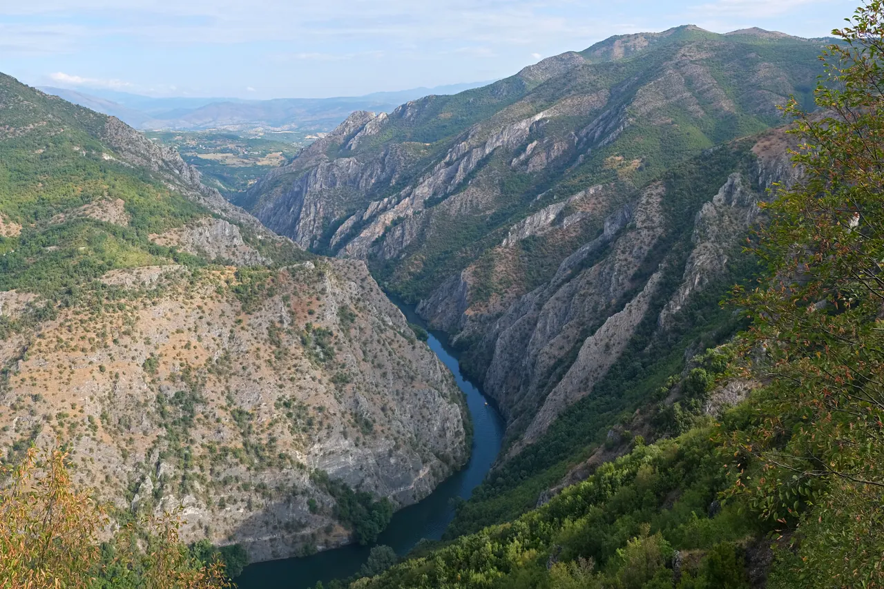 Rocky canyon walls and green slopes above the waters of Matka