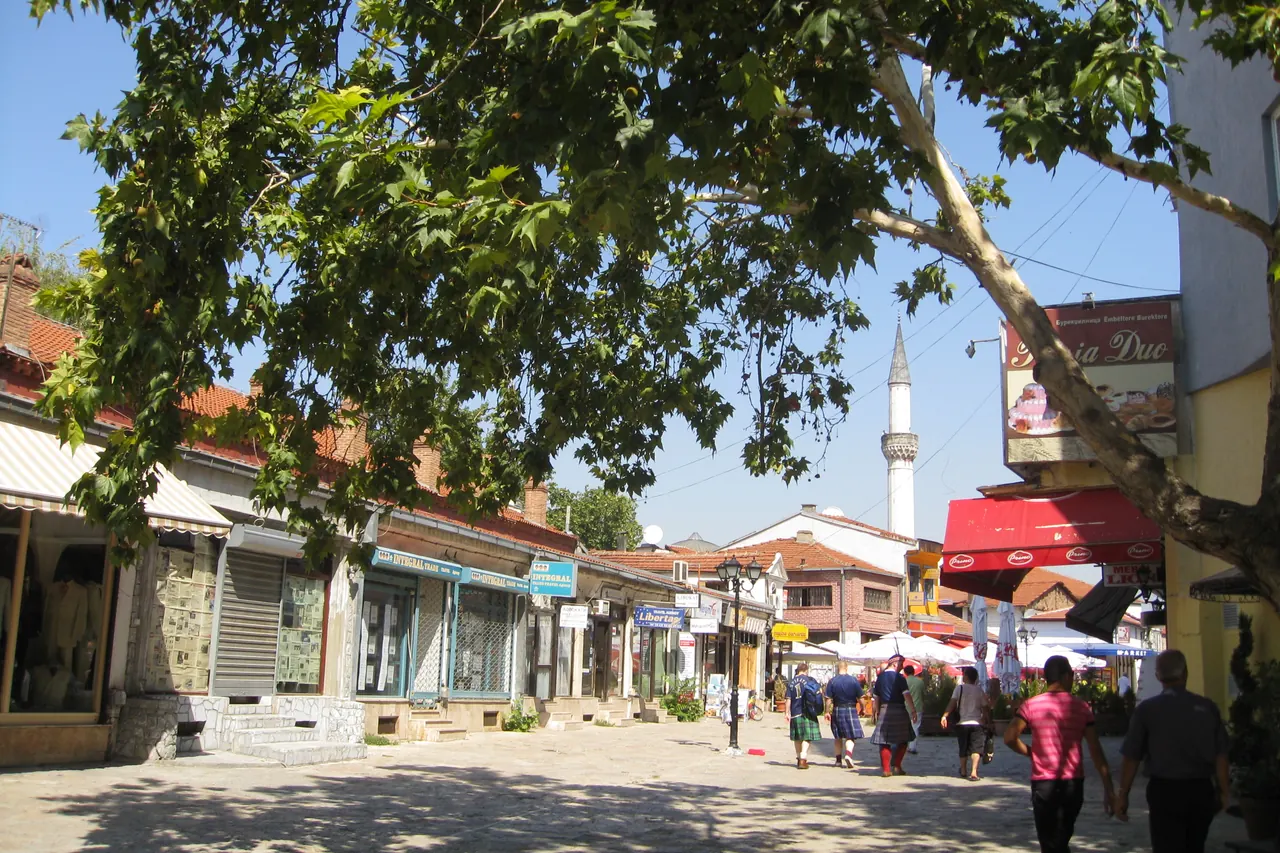 Small shops, pedestrians and trees on a street in Skopje's Old Bazaar