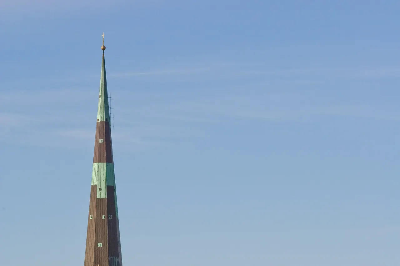 Copper spire of St Olaf's Church against the sky in Tallinn