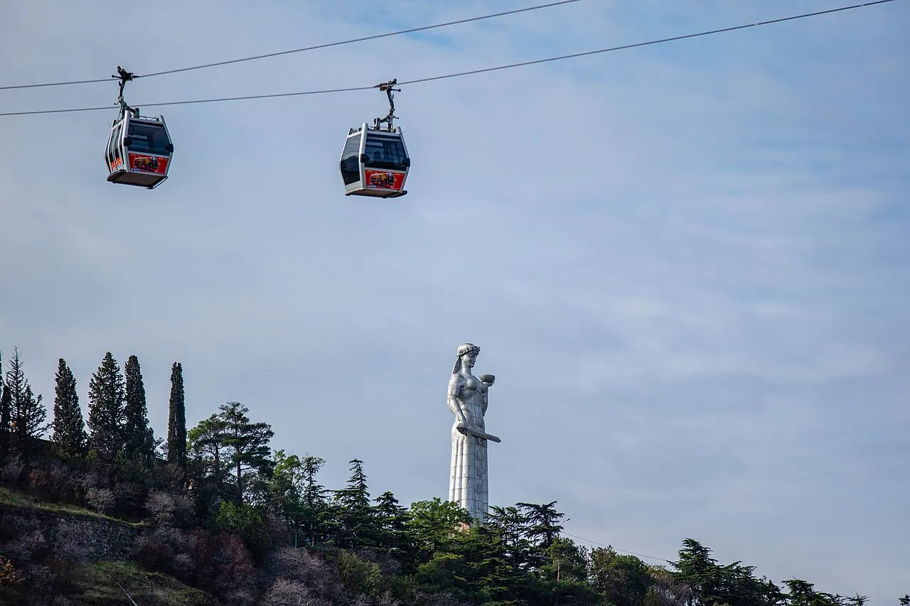The Mother of Georgia statue on the ridge beneath passing cable cars