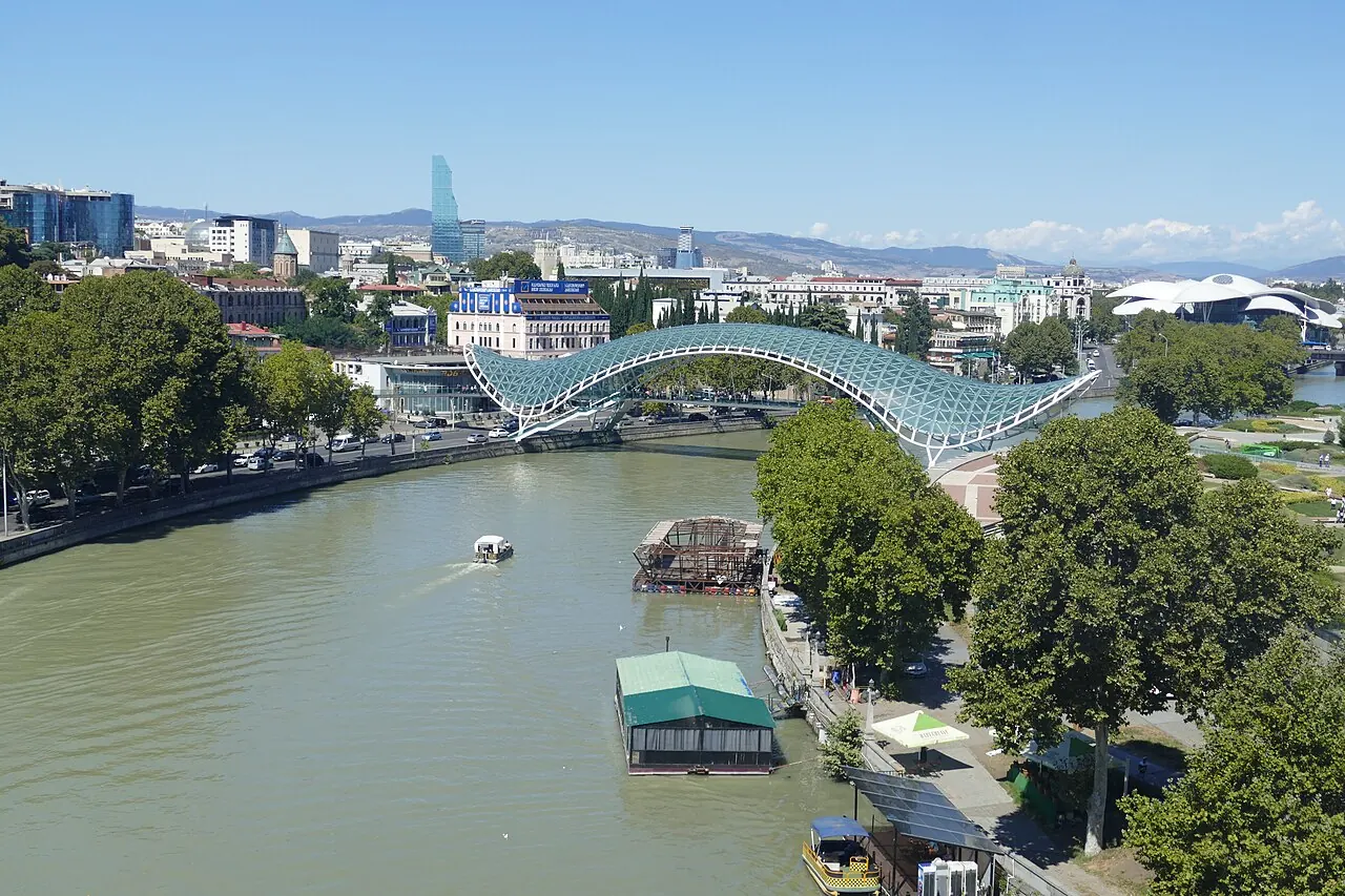 The curved glass canopy of the Bridge of Peace over the Mtkvari River