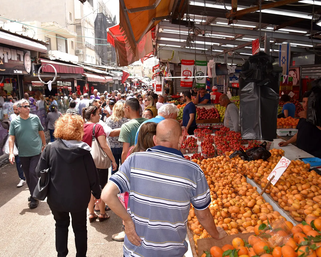 Visitors and produce stalls inside Carmel Market in Tel Aviv