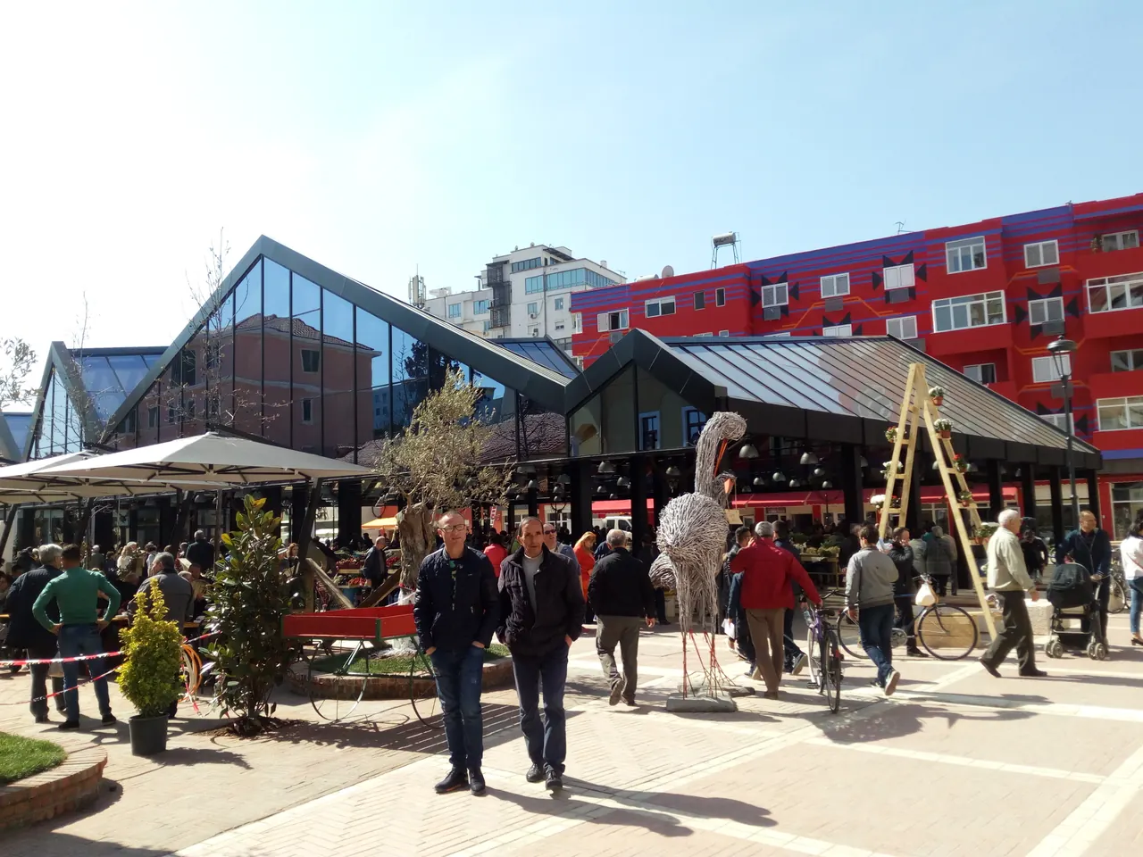 Glass-roofed market pavilions and shoppers in Tirana's New Bazaar