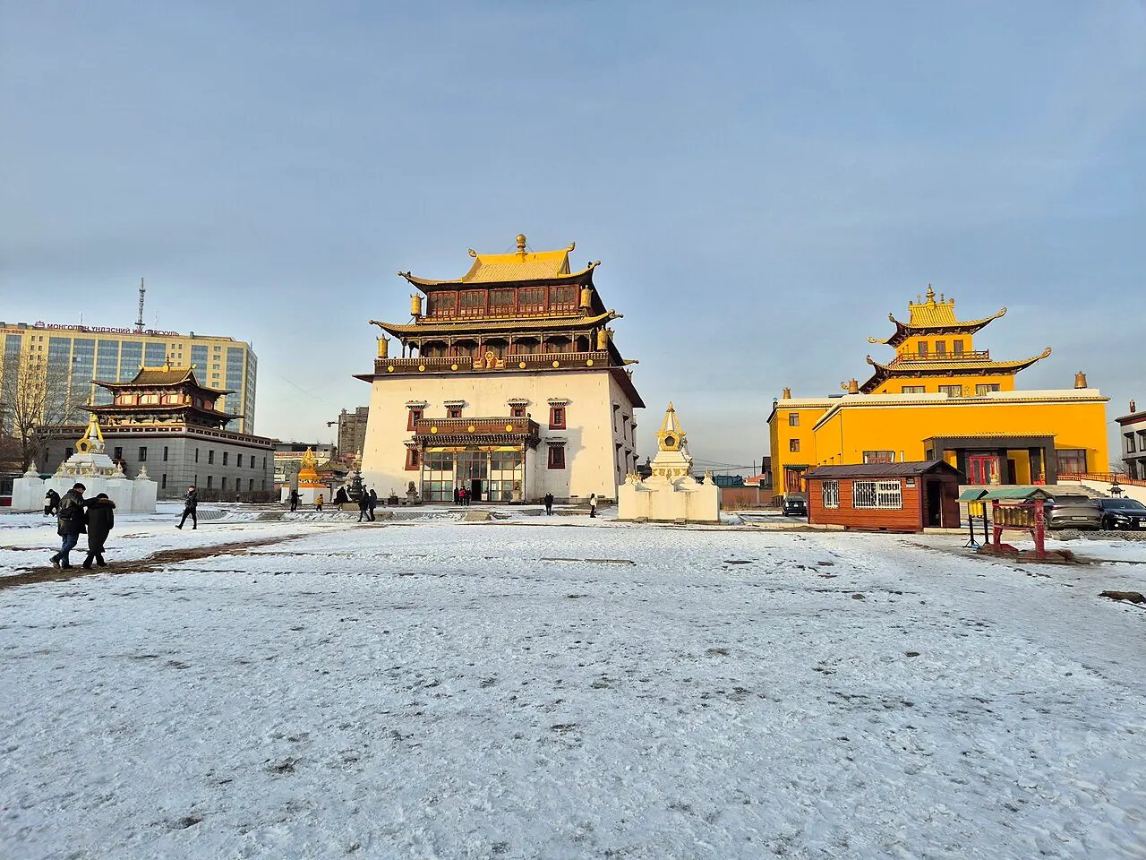 Golden-roofed monastery buildings in the snowy courtyard of Gandantegchinlen in Ulaanbaatar
