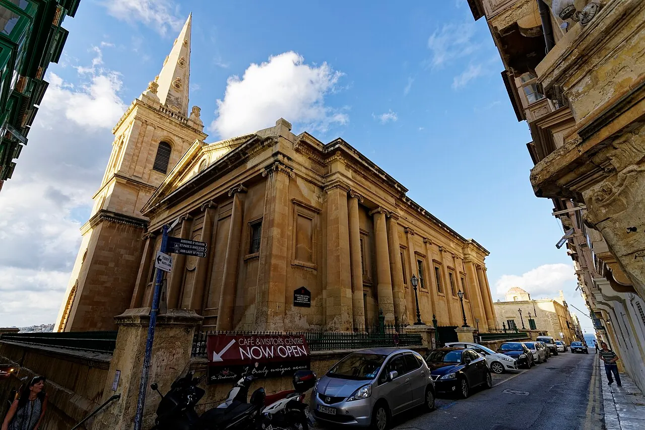St Paul’s Pro-Cathedral’s columned facade and spire along a Valletta street