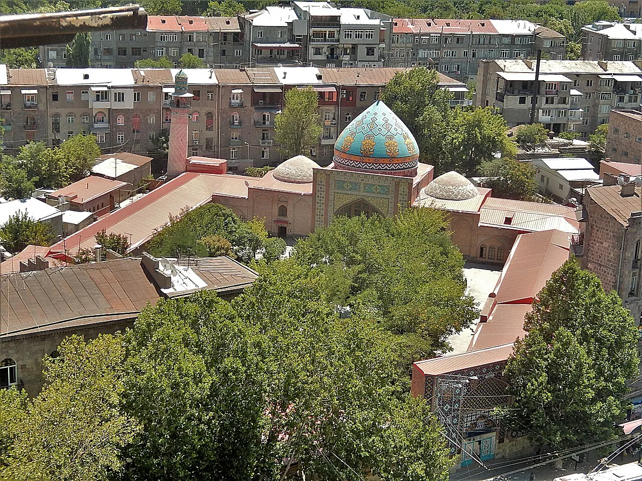 The domed Blue Mosque and its walled courtyard among central Yerevan buildings