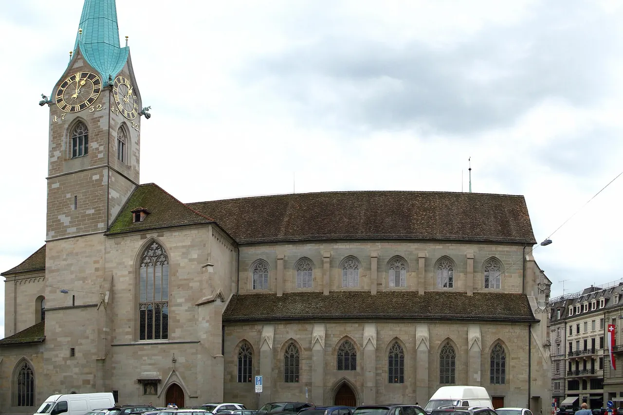 Fraumunster's green spire and church beside the Limmat in Zurich